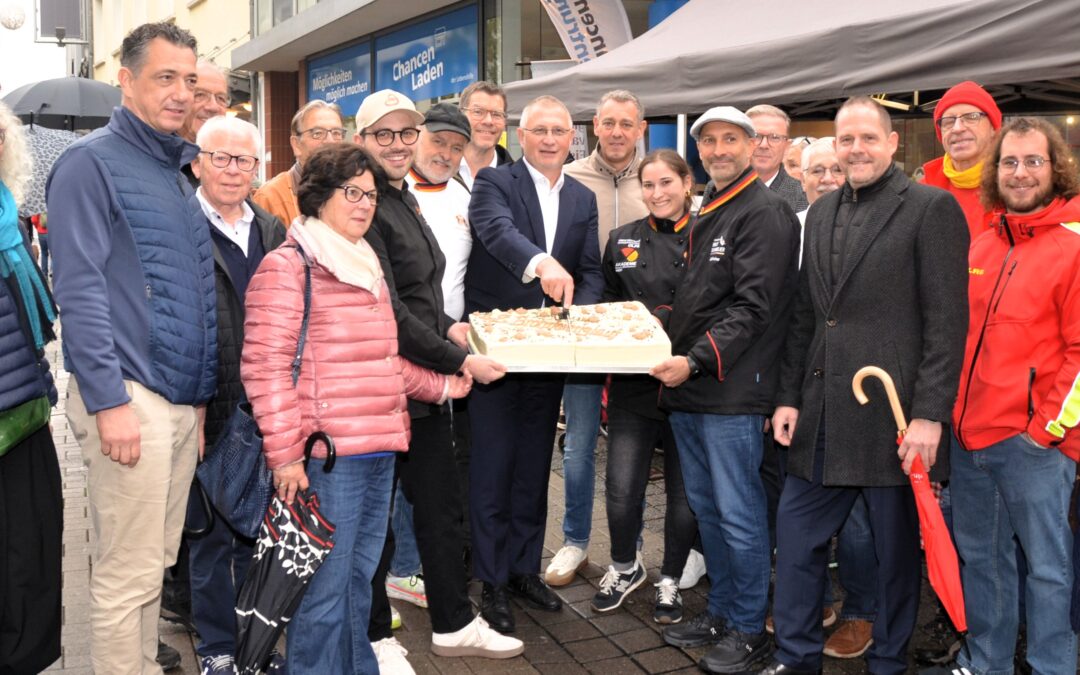 Traditioneller Auftakt der Brotpfennig-Aktion mit Toren-Anschnitt. Diesmal war Holger Wessling von der Sparkasse damit an der Reihe. Madeleine André (rechts neben ihm) hatte die Torte gebacken. Mit auf dem Bild sind neben Initiator Alfred Wenz (linke neben Wessling) die Vertreter der vier begünstigten Hilfsorganisationen Hans-Schumm-Haus (von links), Soonwaldstiftung sowie (von rechts) Hebammenzentrale Hunsrück und DLRG Bad Kreuznach. Auch OB Letz und Kreisbeigeordneter Kohl kamen zum Termin.
